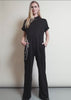 A model wearing The Debbie Harry x Wildfang Jumpsuit shows the fit and features of the product including pockets and stretch
