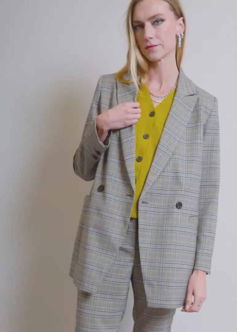 A model wearing The Empower Double Breasted Blazer and Sweater Vest shows the fit and features of the blazer including pockets and stretch